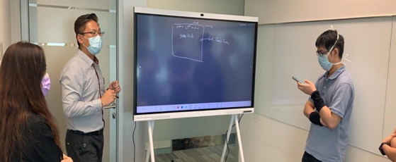 创兴银行员工在会议上使用华为IdeaHub的白板书写功能